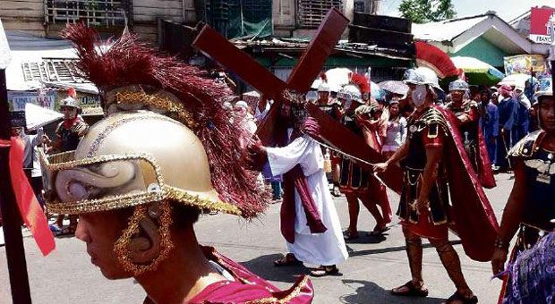 PAMALANDONG Bryan Pacheco, playing the role of Jesus, carries a cross through the streets of Palo, Leyte province, during the Pamalandong passion play on Good Friday. JERICHO VELASCO/CONTRIBUTOR